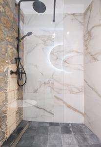 uma casa de banho com chuveiro e paredes em mármore em Casa del Sol Suites in Ilha de Rhodes