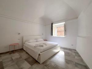 a white bedroom with a bed and a window at Appartamento del centro in Lerici +9 photos