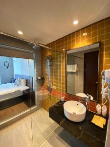 uma casa de banho com um lavatório e uma cabina de duche em vidro. em Apec mandala luxury mũi né em Ấp Long Sơn