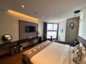 um quarto de hotel com uma cama grande e uma televisão em Apec mandala luxury mũi né em Ấp Long Sơn