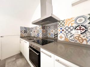 a kitchen with white cabinets and a black stove top oven at Appartamento del centro in Lerici
