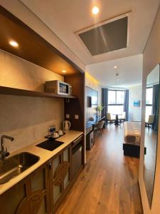 uma cozinha com um lavatório e uma sala de estar em Apec mandala luxury mũi né em Ấp Long Sơn