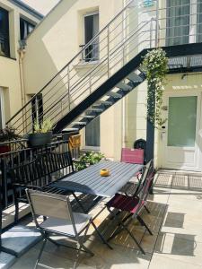 a table and chairs on a patio with a staircase at Best Western Seine West Hotel in Puteaux
