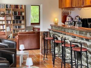 a bar with stools in a room with a stone wall at Chalet Le Panoramique in Mizoën