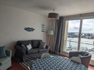 a living room with a couch and a large window at La Vigie sur le Port in Granville