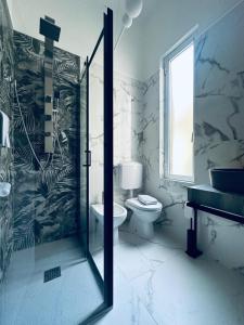uma casa de banho com um WC e uma porta de duche em vidro. em Hotel Villa Marosa em Rapallo