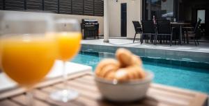 a table with two glasses of orange juice and a bowl of bread at Villa Linea Verde I by Sealand Villas in Tsilivi