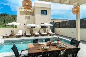 a patio with a table and chairs and a pool at Villa Linea Verde I by Sealand Villas in Tsilivi