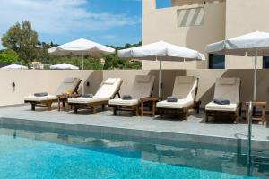 a group of chairs and umbrellas next to a pool at Villa Linea Verde I by Sealand Villas in Tsilivi