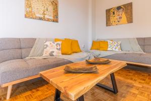 a living room with a couch and a wooden table at Balcony by the bay in Paleo Tsifliki