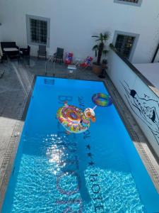 a swimming pool with an inflatable turtle in the water at ROESLI Guest House in Lucerne