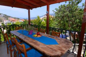 a wooden table with a plate of fruit on a balcony at Villa Sea Bella in Kalkan