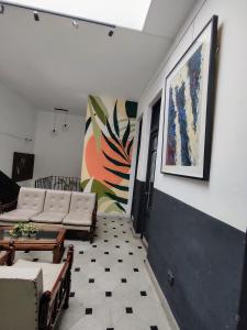 a living room with couches and a painting on the wall at Hostal Vampayá in Salta
