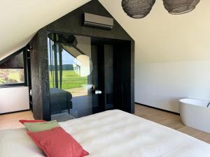 1 dormitorio con 1 cama grande y espejo en Durbuy insolite - Romantic Escape, en Durbuy