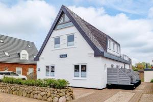 a white house with a gambrel roof at Appartement Krabbe - Haus Neptun in Westerland (Sylt)