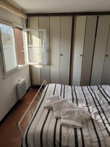 1 dormitorio con 1 cama con 2 toallas en Appartement, prive terrasse, parking et jardin, en Le Boulou