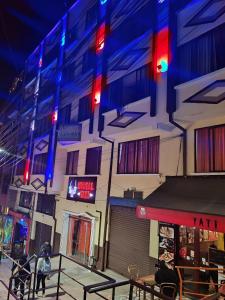 un bâtiment avec des lumières rouges et bleues dans une rue dans l'établissement Yati Hostal, à La Paz