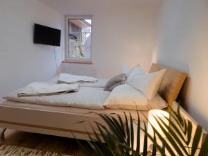 Bett in einem Zimmer mit Fenster und Pflanze in der Unterkunft Apartment Neuwirthof - rustikaler Charme in Sankt Georgen ob Murau