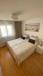 een slaapkamer met een groot wit bed met blauwe kussens bij Apartment Ohana in Medulin
