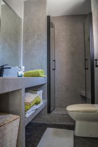 Un baño con lavabo, inodoro y espejo. en Casa Oliver holiday villa Tarifa, garage, pool, en Tarifa