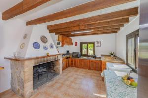une cuisine avec une cheminée en pierre et un comptoir dans l'établissement Villa Can Gosp / Sa Caseta d'en Mateu, à Alcúdia