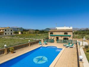 - une piscine avec des chaises et une maison dans l'établissement Villa Can Gosp / Sa Caseta d'en Mateu, à Alcúdia