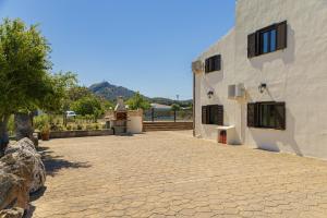un bâtiment avec une allée en pierre à côté d'une maison dans l'établissement Villa Can Gosp / Sa Caseta d'en Mateu, à Alcúdia