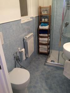 a bathroom with a toilet and a shower and a sink at Appartamento Ostia Enjoy in Lido di Ostia