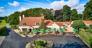 an aerial view of a house with a yard with umbrellas at Pine Boutique Lodge with hot tub for couples & dog in York