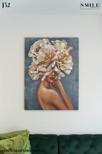 a painting of a woman with a large flower at Smile Apartments in Bucharest