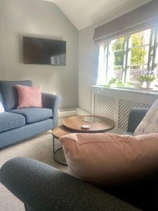 uma sala de estar com um sofá e uma mesa em The White Hart Apartment Valley View em Alton