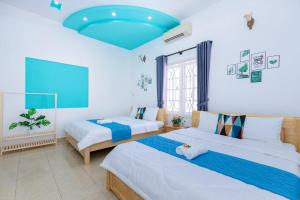 ブンタウにあるVilla Hồ Bơi Karaoke - Bida - Sân Vườn - Gần Biển Thùy Vânの青い天井の客室で、ベッド2台が備わります。