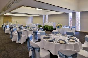 - une salle de banquet avec des tables et des chaises blanches dans l'établissement Hawthorne Inn & Conference Center, à Winston-Salem
