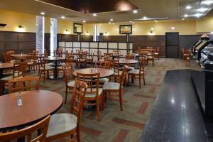 une salle à manger avec des tables et des chaises en bois dans l'établissement Hawthorne Inn & Conference Center, à Winston-Salem