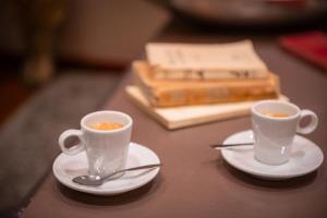 two cups of coffee on plates on a table at Hotel George Sand Opéra Paris in Paris