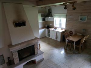 eine Küche und ein Wohnzimmer mit einem Kamin und einem Tisch in der Unterkunft Domek nad Czarną Hańczą - Przystań Kajakowa Zakole in Krasnopol