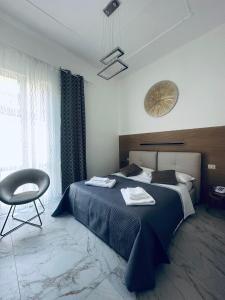 a bedroom with a bed and a chair and a window at Hotel Villa Marosa in Rapallo