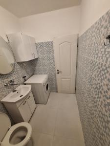 uma casa de banho com um WC, um lavatório e uma porta em Apartments Lena em Herceg Novi