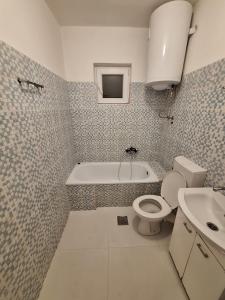 uma casa de banho com uma banheira, um WC e um lavatório. em Apartments Lena em Herceg Novi