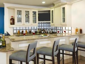 a kitchen with a bar with chairs and wine bottles at Hilton Garden Inn Washington DC/Greenbelt in Greenbelt
