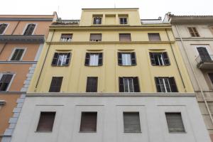 un edificio giallo con finestre in cima a un edificio di Holidays in Rome - Guesthouse a Roma