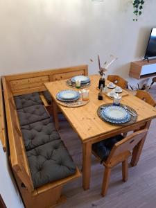 una mesa de madera y sillas con platos y platos. en Harmony Suite Dolomiti - Mountain & Lake, en Saone