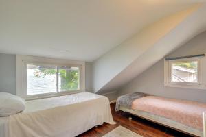 1 dormitorio con 2 camas y 2 ventanas en Coastal Lake Erie Cottage with Amazing Water Views! en Euclid