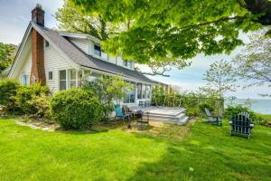una casa con porche y césped en Coastal Lake Erie Cottage with Amazing Water Views! en Euclid