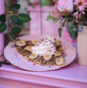 a dessert with whipped cream and bananas on a plate at SWISS CONTINENTAL HOTEL Free Cooking Classes in Marrakech