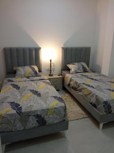 2 nebeneinander sitzende Betten in einem Schlafzimmer in der Unterkunft Ben arous one in Ben Arous