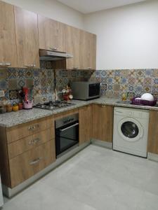 een keuken met een fornuis en een wasmachine bij Ben arous one in Ben Arous