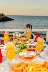 a table with food and drinks on a table by the ocean at Mare Blu Hotel in Trabzon
