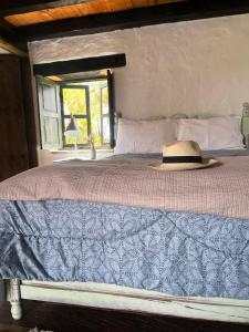ein Bett mit einem Hut drauf in der Unterkunft Casona Ananda in Firavitoba