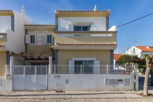 een huis met een hek ervoor bij Villa Amarela by AlgarveManta in Manta Rota
